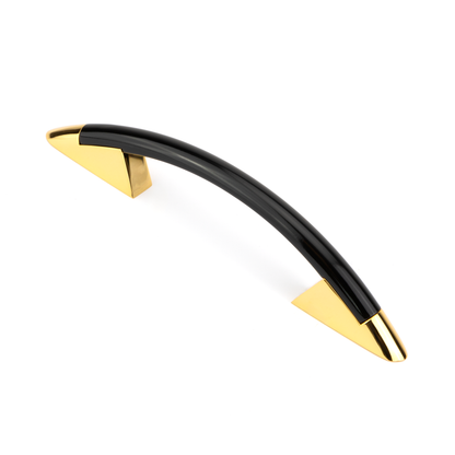 Design-Bogengriff Ruza 96 mm Kombination Schwarz glaenzend lackiert Griffleiste und Gold glaenzend galvanisiert Grifffuss stehend auf weissem Hintergrund