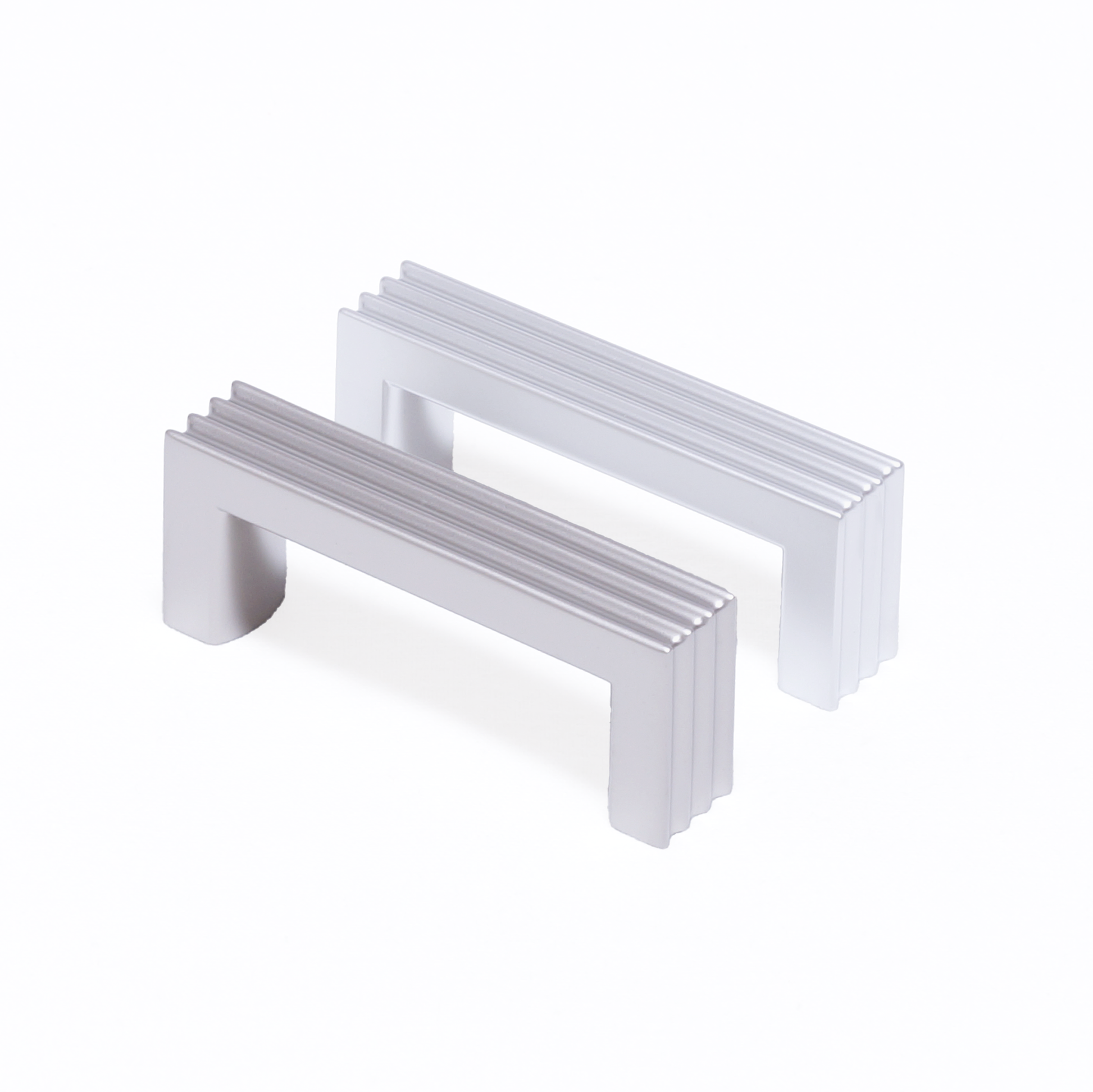 Zwei Design-Bügelgriffe Kamala 64 mm nebeneinander in Nickel matt und Chrom matt galvanisiert auf weißem Hintergrund